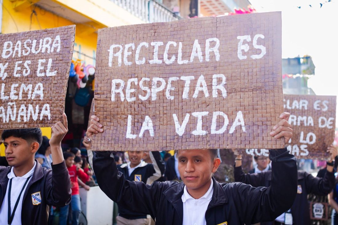 Estudiantes en desfile con mensajes de reciclaje